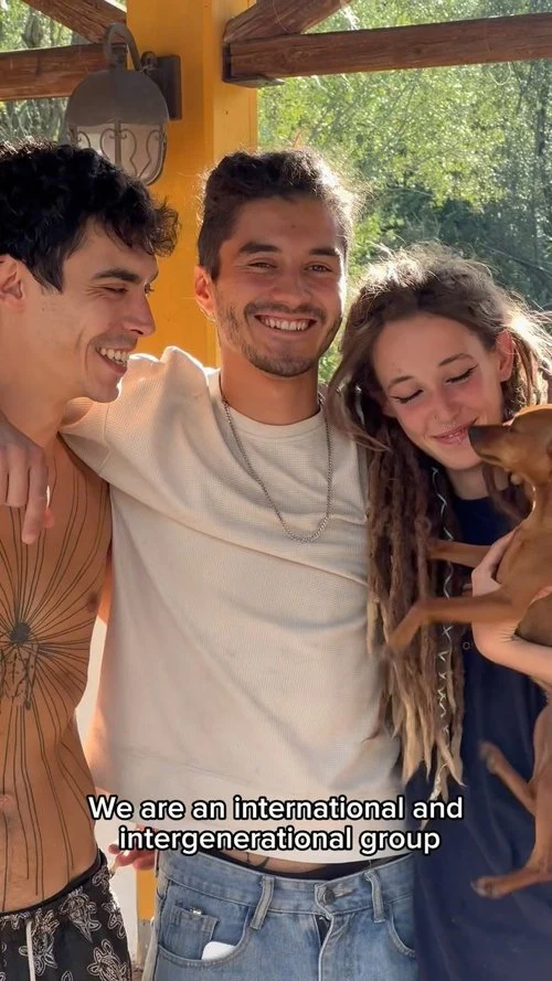 An international group of Honeydew volunteers laughing together with a dog